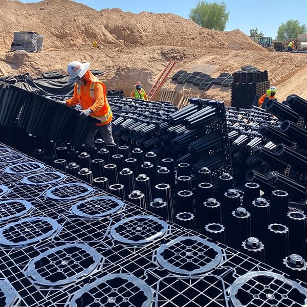 ACO StormBrixx geocellular stormwater modules being brick-bonded into an underground detention tank during installation